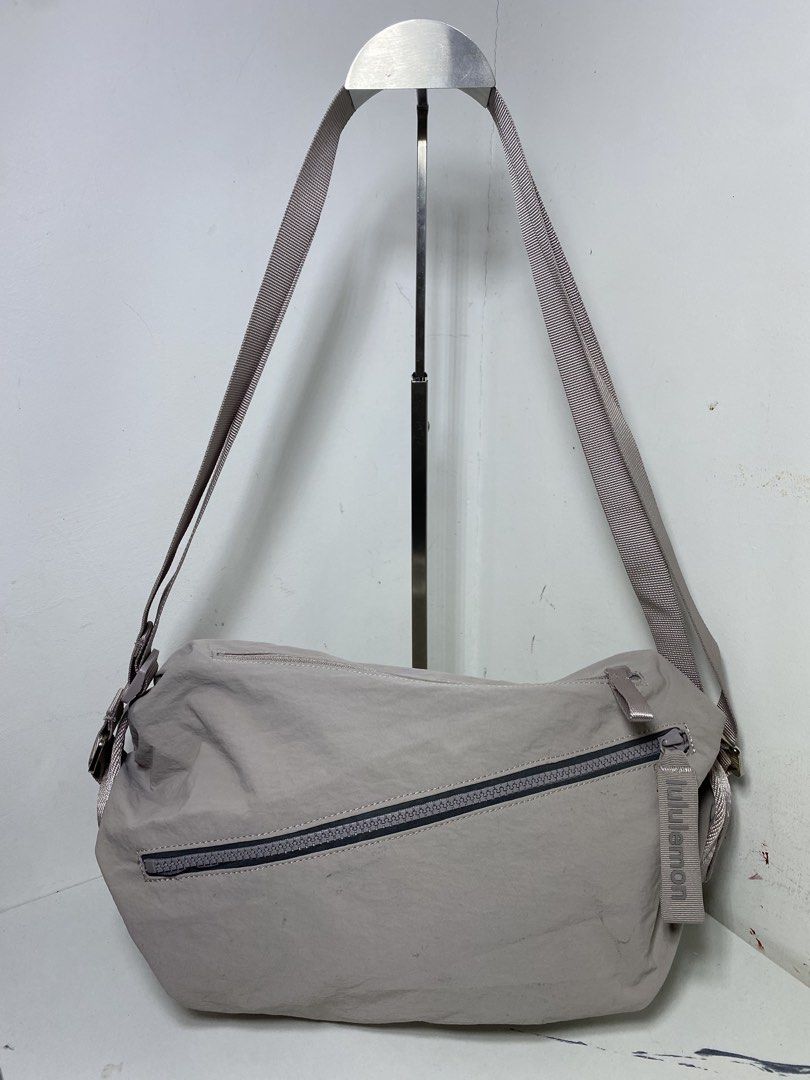 Lululemon Crossbody Bag Light Grey Nylon (Category: Cross-body Bags) located in Manila. Submitted by onfleekapparelph (Listing ID 1466168676, Image 1). Description: - Brand: Lululemon - Style: Crossbody Bag - Material: Durable light grey nylon - Hardware: Premium metallic hardware with adjustable shoulder strap - Pockets: Front diagonal zipper pocket and interior zipper pocket - Details: Features branded pull tab and white Lululemon fabric logo t