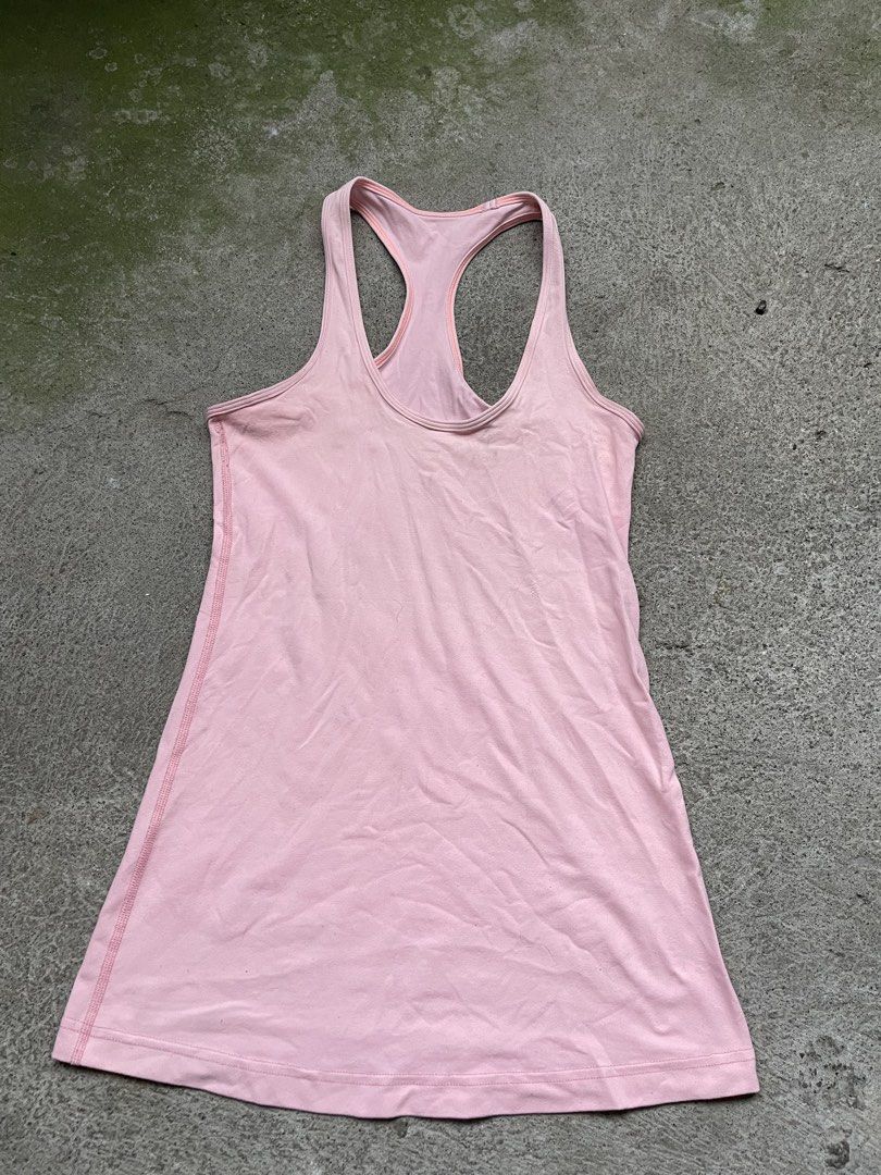 Lululemon Pink Tank Top (Category: Sleeveless) located in Siniloan. Submitted by rethr1ft (Listing ID 1466245068, Image 2). Description: - 27 length | 14 width - Brand: Lululemon - Color: Light pink with contrast orange piping - Style: Racerback, snug fit, long length - Details: Reflective silver omega logo on the back - Material: Stretchy, high-performance workout fabric - Condition: Excellent/Pre-loved (ready for yoga or runs).