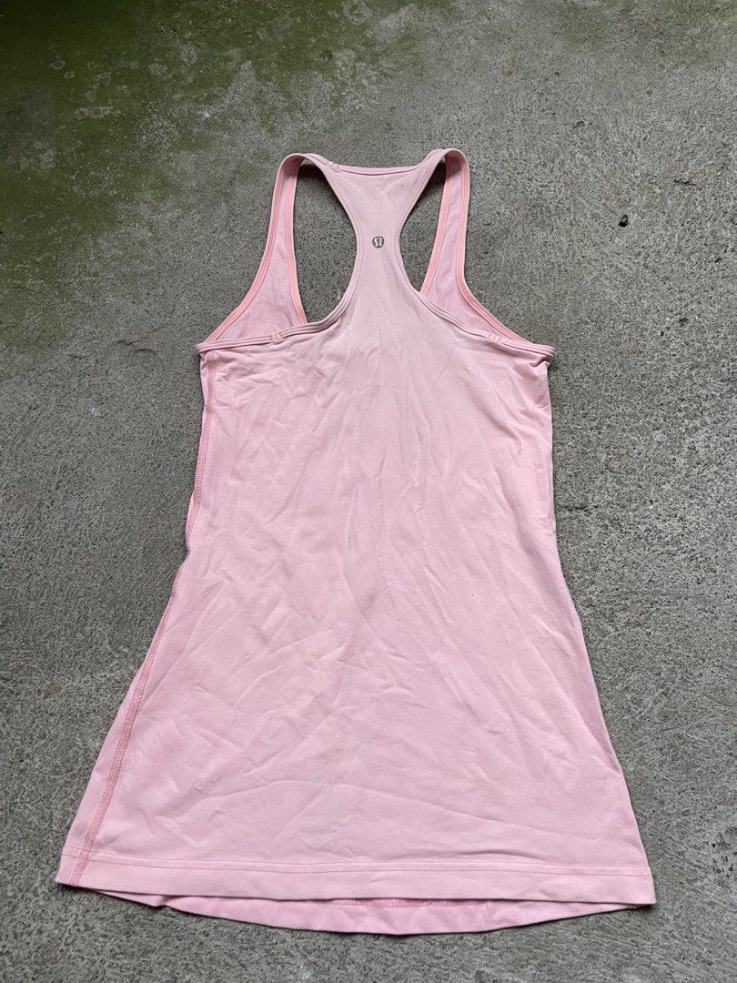 Lululemon Pink Tank Top (Category: Sleeveless) located in Siniloan. Submitted by rethr1ft (Listing ID 1466245068, Image 1). Description: - 27 length | 14 width - Brand: Lululemon - Color: Light pink with contrast orange piping - Style: Racerback, snug fit, long length - Details: Reflective silver omega logo on the back - Material: Stretchy, high-performance workout fabric - Condition: Excellent/Pre-loved (ready for yoga or runs).