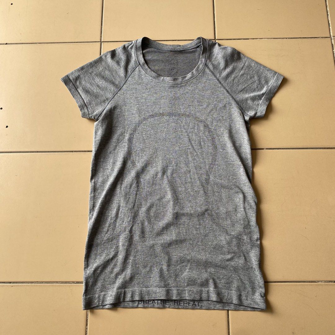 Lululemon Swiftly Tech Short Sleeve Crew Grey Size 6 (Category: Shirts) located in Bogo. Submitted by royalivio069630 (Listing ID 1466172662, Image 1). Description: Grey short sleeve athletic top from Lululemon. Size 6 printed inside the hem. Seamless knit fabric with textured detailing down the back and subtle motivational phrases printed near the bottom hem including 'BREATHE. REPEAT.' and 'MOVEMENT IS MEDICINE'. Classic crew neck style, great 
