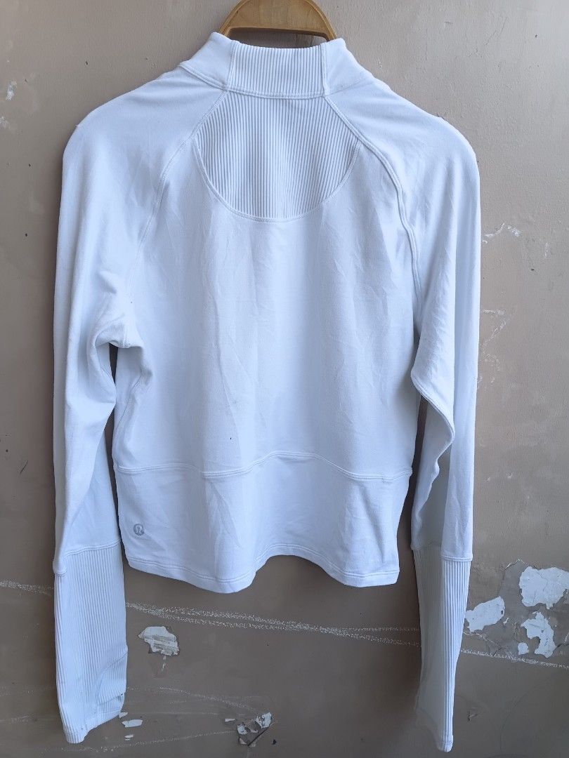 Lululemon White Ribbed Half Zip Hoodie Jacket (Category: Coats, Jackets and Outerwear) located in Manila. Submitted by grandflower-547aee (Listing ID 1466180423, Image 2). Description: - Brand: Lululemon - Color: Clean white - Style: Half-zip hoodie with high collar - Features: Ribbed back panel, extra-long ribbed cuffs with thumbholes, signature logo silver zipper pull, and small heat-pressed logo on lower back hem - Material: Soft and comfortab