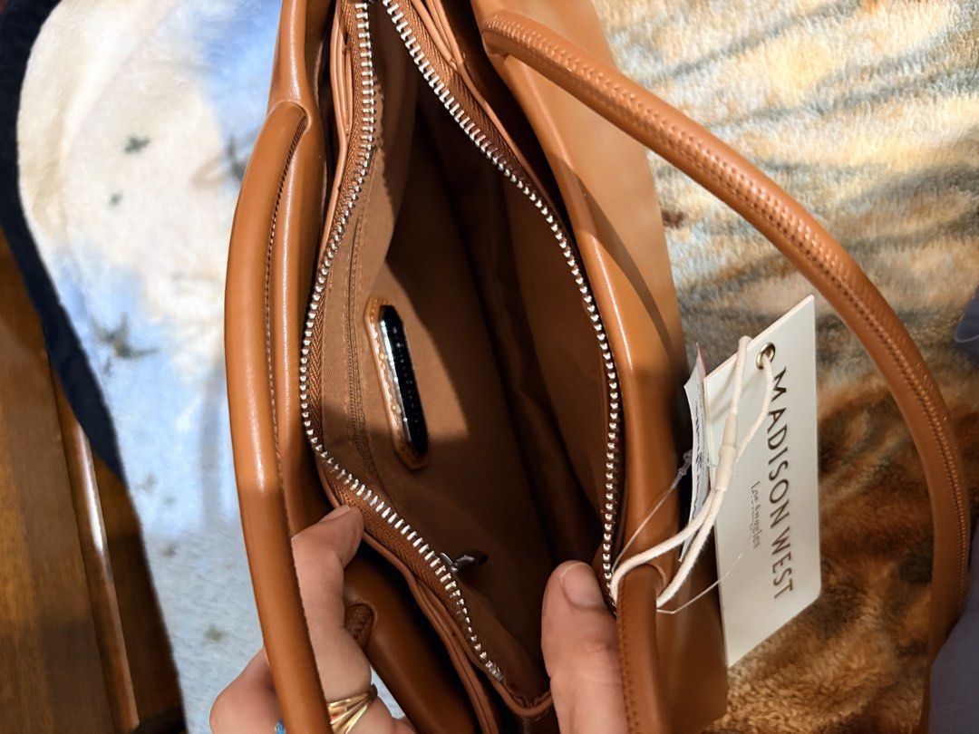 Madison West Brown Shoulder Bag (Category: Shoulder Bags) located in Subic. Submitted by aralleiah (Listing ID 1466181917, Image 3). Description: - Brand: Madison West Los Angeles - Color/Material: Brown faux leather - Condition: Brand new with Marshalls store tag attached (Compare at $40) - Closure: Top zipper and magnetic snap compartment - Straps: Slim double straps for comfortable shoulder wear - Interior: Lined with a convenient zippered sid