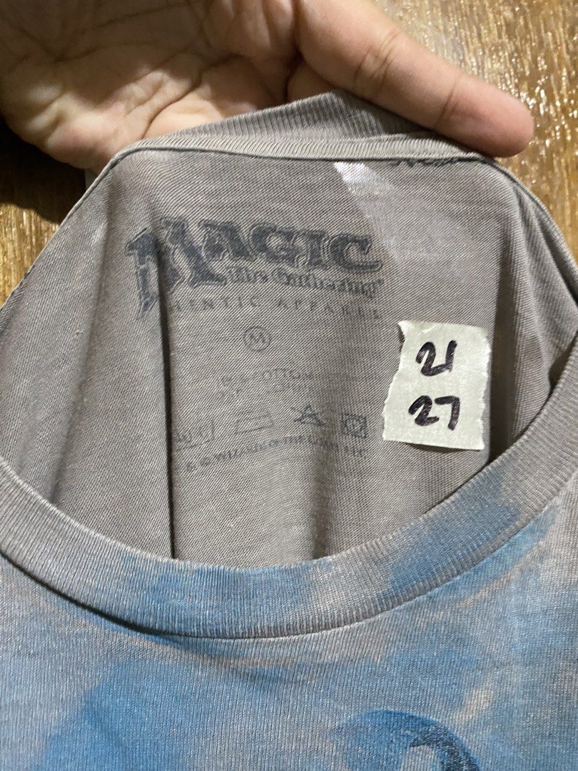 Magic The Gathering Graphic Tee Grey Blue Size M (Category: Tshirts & Polo Shirts ) located in Imus. Submitted by frootiloots4103 (Listing ID 1466207976, Image 2). Description: - Official Magic: The Gathering graphic tee - Color: Grey with large blue character print on the front - Size: Medium (Width: 21 inches, Length: 27 inches) - Material: Comfortable cotton with a tagless printed neck label - Style: Casual, great for daily wear and TCG fans -