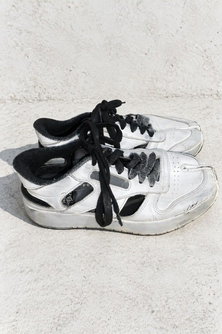 Maison Margiela x Reebok (Category: Sneakers) located in Baguio. Submitted by luxeloomarchive (Listing ID 1466173619, Image 3). Description: Maison Margiela x Reebok ​Description: Iconic Maison Margiela x Reebok Project 0 CL Tabi Decortique Low-Top Sneakers. Features Margiela's signature split Tabi toe design, 'Decortique' cut-out side paneling, hand-painted distressed white finish over a black base, lace-up closure, and dual branding on the tong