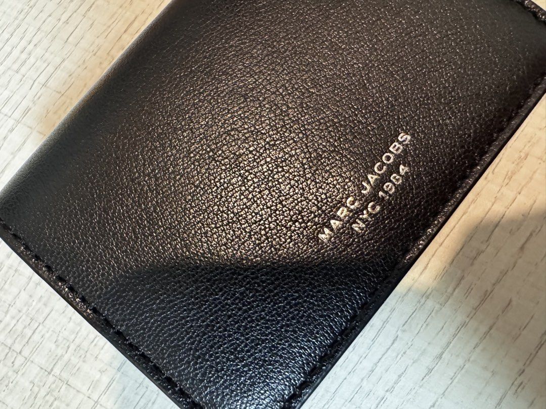 Marc Jacobs Black Leather Trifold Wallet (Category: Luxury Bags & Wallets) located in Paranaque City. Submitted by lersprelovedclothes (Listing ID 1466255103, Image 1). Description: - Authentic Marc Jacobs NYC 1984 trifold wallet - Premium black grained leather with silver foil logo lettering - Secure snap button closure - Multiple card slots and slip compartments - Compact size, perfect for small bags and pockets - Clean interior with subtle bra