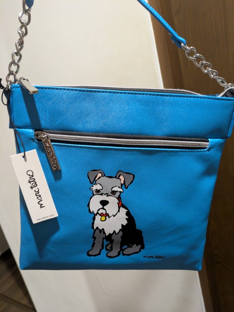 Marc Tetro Blue Schnauzer Slingbag (Category: Cross-body Bags) located in Quezon City. Submitted by countess_86 (Listing ID 1466276319, Image 1). Description: - Brand: Marc Tetro - Color: Bright blue with cute schnauzer graphic on front - Hardware: Silver-tone with chain strap details - Compartments: Secure zippered compartments - Strap: Adjustable with buckle for a custom fit - Condition: Brand new with original tag attached - bought from Canada