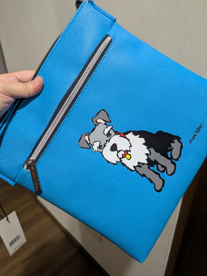 Marc Tetro Blue Schnauzer Slingbag (Category: Cross-body Bags) located in Quezon City. Submitted by countess_86 (Listing ID 1466276319, Image 3). Description: - Brand: Marc Tetro - Color: Bright blue with cute schnauzer graphic on front - Hardware: Silver-tone with chain strap details - Compartments: Secure zippered compartments - Strap: Adjustable with buckle for a custom fit - Condition: Brand new with original tag attached - bought from Canada