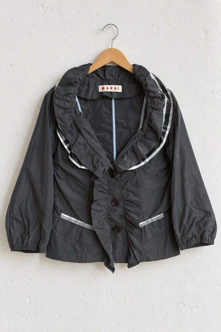 Marni Ruffled Collar Lightweight Jacket (Category: Coats, Jackets and Outerwear) located in Baguio. Submitted by luxeloom099 (Listing ID 1466172988, Image 1). Description: Brand: Marni ​Description: Elevate your outerwear with this designer Marni Ruffled Collar Lightweight Jacket made in Italy. Crafted from a cotton-nylon blend, it features statement ruffle trim around the oversized collar and front button placket, plaid/striped trim accents alon
