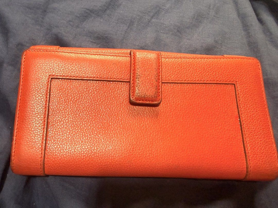 MCM Red Leather Long Wallet (Category: Luxury Bags & Wallets) located in Manila. Submitted by rrtolibas48132 (Listing ID 1466286275, Image 3). Description: - Brand: MCM München - Material: Red pebbled leather - Hardware: Gold-tone plaque with engraved serial number 12488 - Features: Clear ID window, multiple card slots, and exterior back snap pocket - Interior: Stamped with the official MCM logo - Condition: Normal wear on the leather grain and e