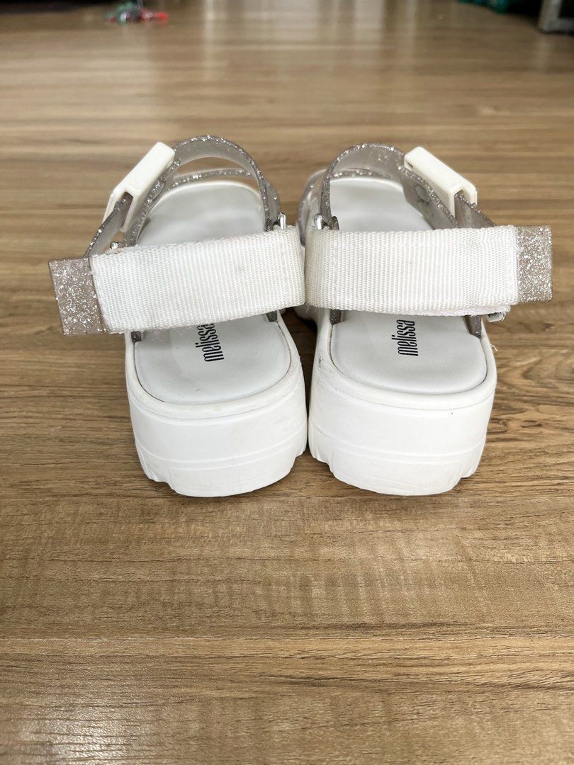 Melissa Glitter Platform Sandals White Silver Size 7 (Category: Flats & Sandals) located in Manila. Submitted by lorenasant37621 (Listing ID 1466207405, Image 3). Description: - Brand: Melissa - Style: Platform sandals with chunky lug sole and transparent glitter straps - Color: White and sparkly silver - Material: Vegan - Size: US 7 / EUR 38 / BRA 36 - Closure: Velcro back strap with buckle detail - Condition: Worn a few times, slight dirt marks