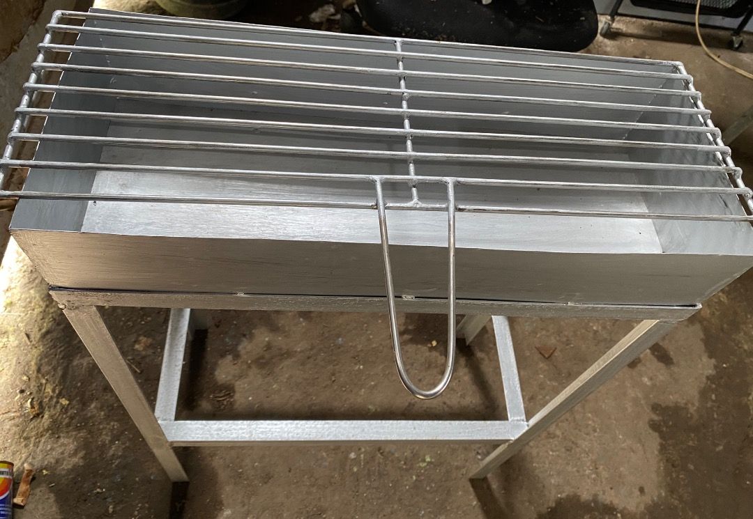 Metal charcoal BBQ grill with stand (Category: BBQ, Grills & Hotpots) located in Caloocan City. Submitted by beaumontca47615 (Listing ID 1466205797, Image 1). Description: - Sturdy, heavy-duty metal barbecue grill in a sleek silver-grey finish - Includes a deep fire box tray for better heat retention - Removable cooking grate equipped with a convenient handle - Supporting frame stand featuring a lower storage shelf for grilling essentials - Ideal