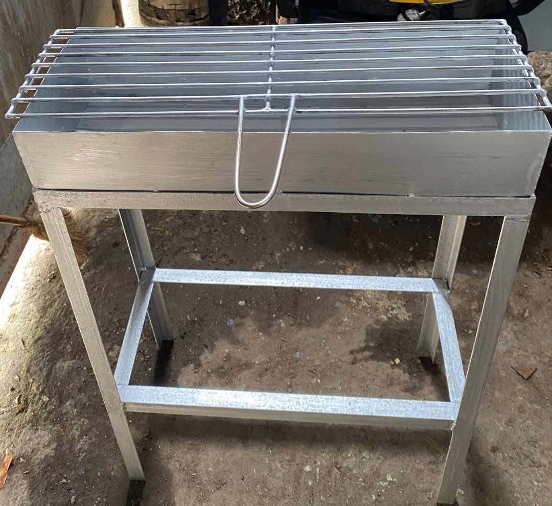 Metal charcoal BBQ grill with stand (Category: BBQ, Grills & Hotpots) located in Caloocan City. Submitted by beaumontca47615 (Listing ID 1466205797, Image 2). Description: - Sturdy, heavy-duty metal barbecue grill in a sleek silver-grey finish - Includes a deep fire box tray for better heat retention - Removable cooking grate equipped with a convenient handle - Supporting frame stand featuring a lower storage shelf for grilling essentials - Ideal