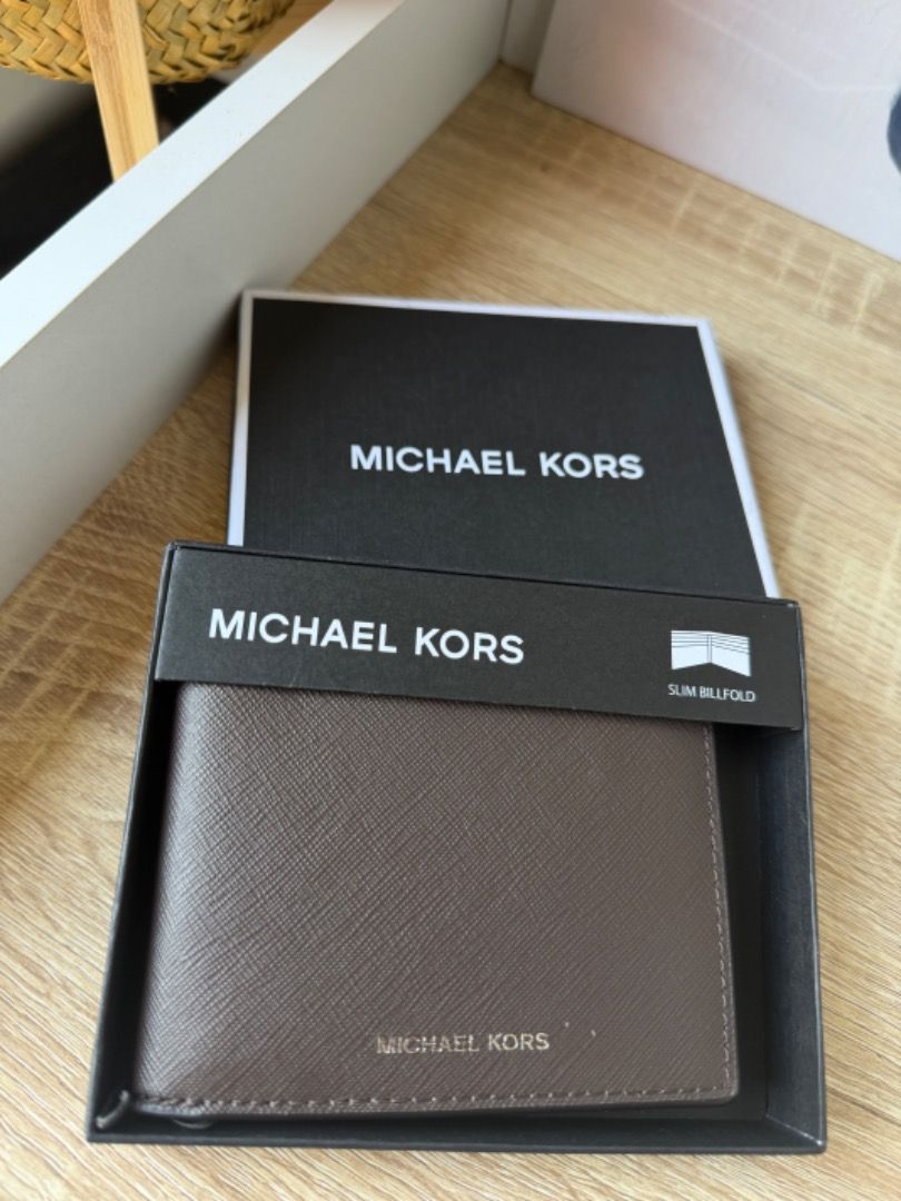 Michael Kors Andy Slim Billfold Wallet Brown (Category: Luxury Bags & Wallets) located in Koronadal. Submitted by marielle.q (Listing ID 1466274662, Image 1). Description: - Brand: Michael Kors - Model: Andy Slim Billfold Wallet - Color: Brown with silver lettering - Material: Saffiano leather texture - Features: Multiple card slots for daily essentials - Condition: Brand new with original tag (MSRP $98) - Inclusions: Matching Michael Kors gift b