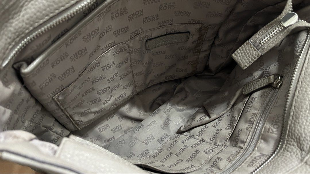 Michael Kors Bedford Tote Bag (Category: Tote Bags) located in Cavite. Submitted by clarebearxx (Listing ID 1466276699, Image 3). Description: A grey pebbled leather Michael Kors Bedford Tote Bag, highlighted by a matching removable leather tassel charm and polished silver-tone ring attachments. About the item: 📌 Personal bought by my aunt from Canada Outlet 📌 used item but well taken cared of but expect signs of usage 📌 with tag inside Mode o