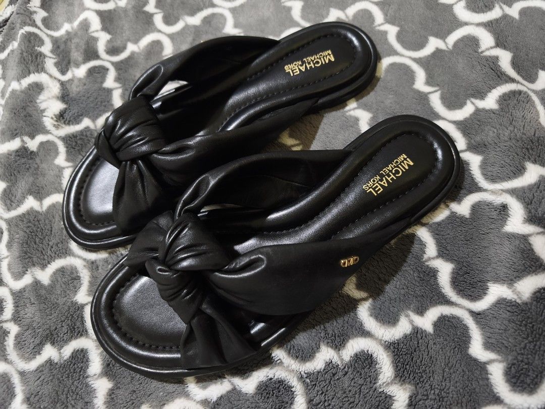 Michael Kors Black Knotted Flat Sandals (Category: Flats & Sandals) located in Manila. Submitted by krisellerxoxo (Listing ID 1466171148, Image 1). Description: - Brand: Michael Kors - Style: Slip-on flat sandals in classic black - Details: Soft padded strap, stylish front knot, gold embossed footbed logo, and side MK metal hardware - Fit & Comfort: Extremely comfortable for daily use and effortless styling.