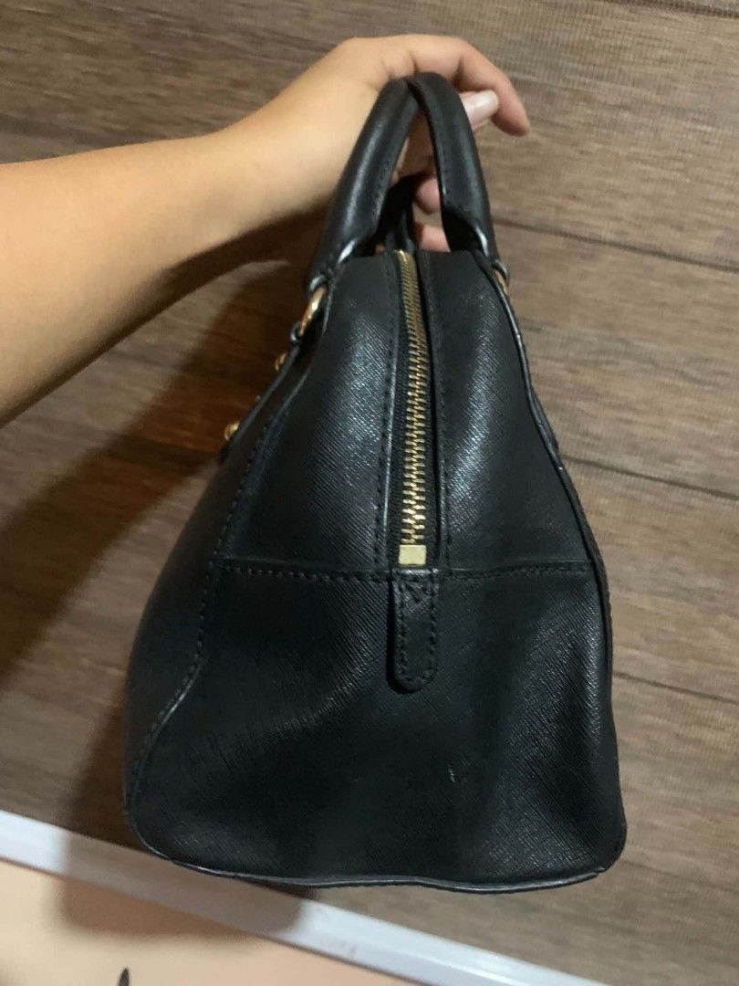 Michael Kors Black Satchel Handbag (Category: Luxury Bags & Wallets) located in Aliaga. Submitted by akishaoshop2010. (Listing ID 1466204349, Image 2). Description: - Brand: Michael Kors - Color: Classic Black with premium gold-tone hardware - Material: Durable Saffiano leather texture - Closure: Secure top zipper closure - Handles: Convenient dual rolled top handles - Base: Protective metal feet to prevent wear and tear - Detail: Iconic front go