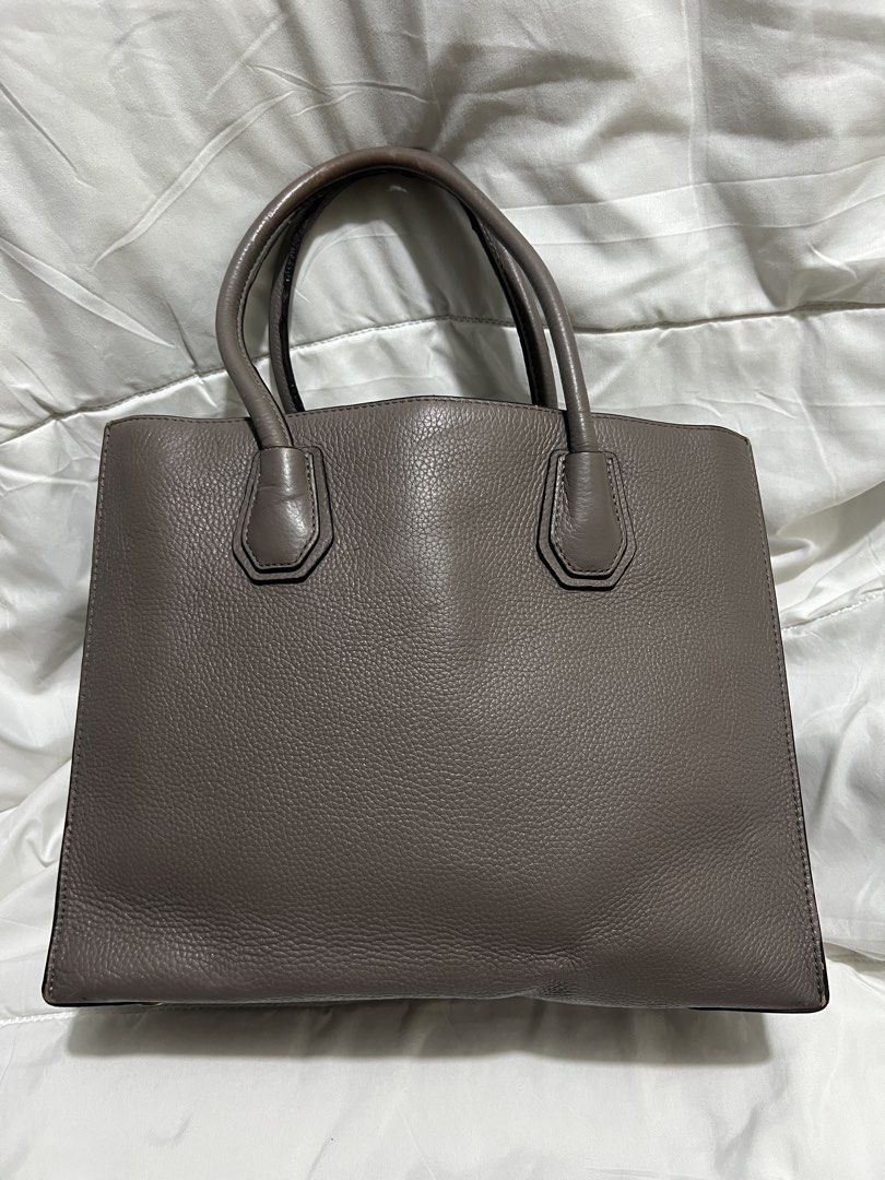 Michael Kors Mercer Medium Grey Leather Tote Bag (Category: Tote Bags) located in Pasig City. Submitted by madiesbags (Listing ID 1466328315, Image 3). Description: - Brand: Michael Kors - Material: Taupe grey pebble leather with silver hardware - Design: Structured base with metal feet and signature padlock charm - Interior: Fabric-lined with multiple compartments and a secure zippered pocket - Closure: Top zip closure for security - Condition: 