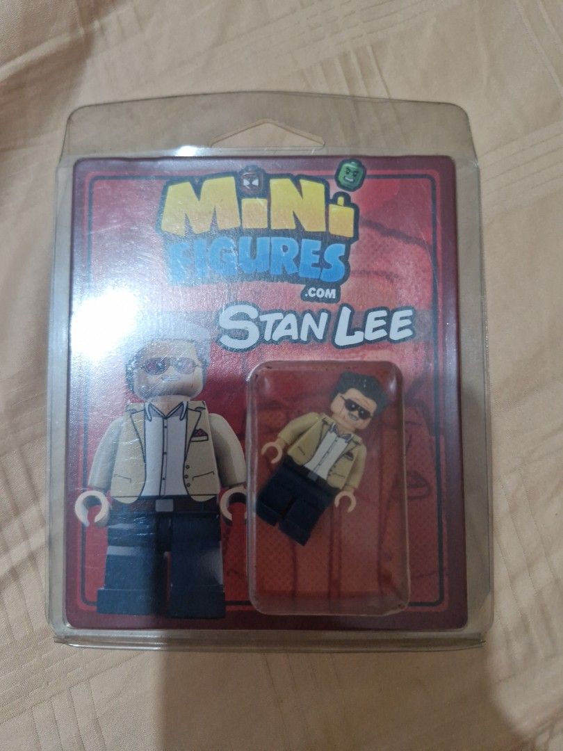 miniffigures.com Stan Lee LEGO compatible custom minifigure (Category: Figurines & Statues) located in Manila. Submitted by kingtlc (Listing ID 1466284110, Image 1). Description: - Brand: Minifigures.com (Custom Stan Lee) - Condition: Brand new, sealed in original blister pack with backing card - Includes: Sunglasses, tan jacket, white shirt, and dark trousers - Perfect for: Marvel fans and toy collectors.