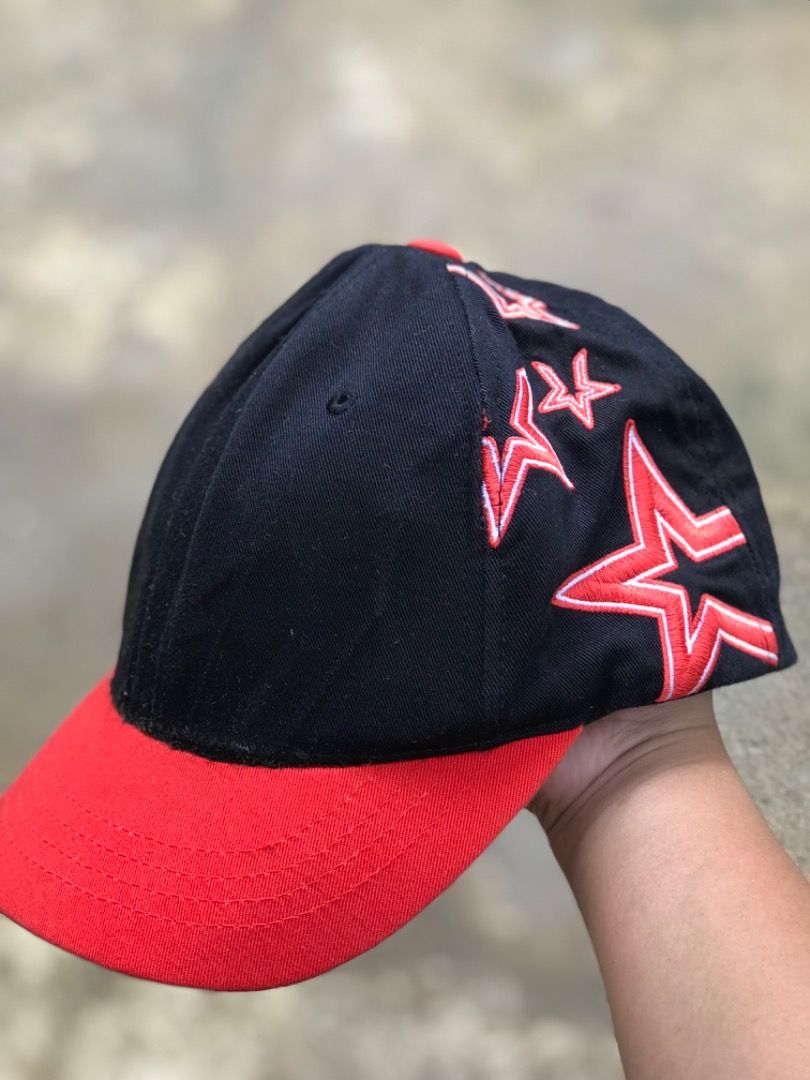 MLB Black And Red Star Baseball Cap (Category: Caps & Hats) located in Jimenez. Submitted by onlythrifty_ (Listing ID 1466210502, Image 1). Description: - Authentic MLB baseball cap in sleek black with vibrant red details - Features eye-catching red embroidered stars along the side and back panels - Bold bright red brim adds a standout pop of color - Adjustable strap closure at the back for a customizable, comfortable fit - Official MLB branding 