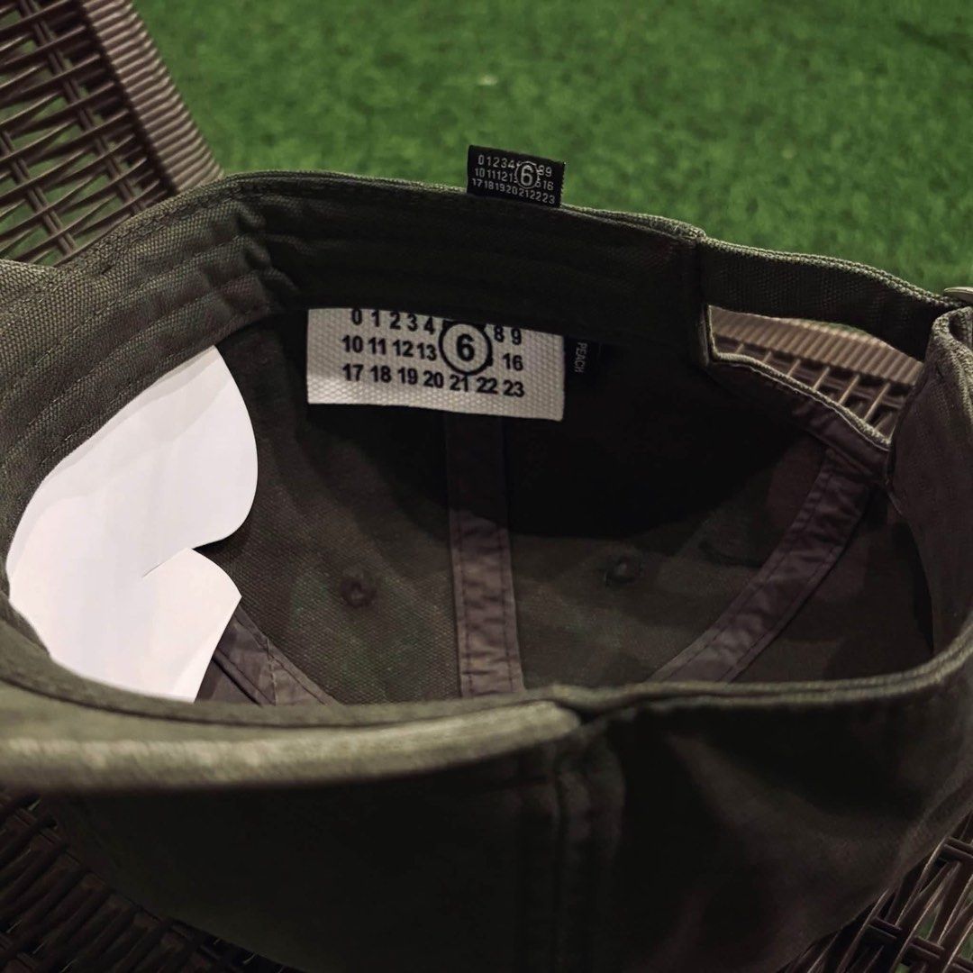 MM6 Maison Margiela Number Logo Baseball Cap (Category: Caps & Hats) located in Santa Rosa. Submitted by klarksantos (Listing ID 1466280112, Image 2). Description: - Brand/Model: MM6 Maison Margiela baseball cap - Color: Dark grey with a washed finish - Material: Sturdy canvas - Details: Subtle embroidered numeric logo on the front, interior numeric branding labels - Closure: Adjustable metal strap at the back - Condition: Barely worn, clean shap