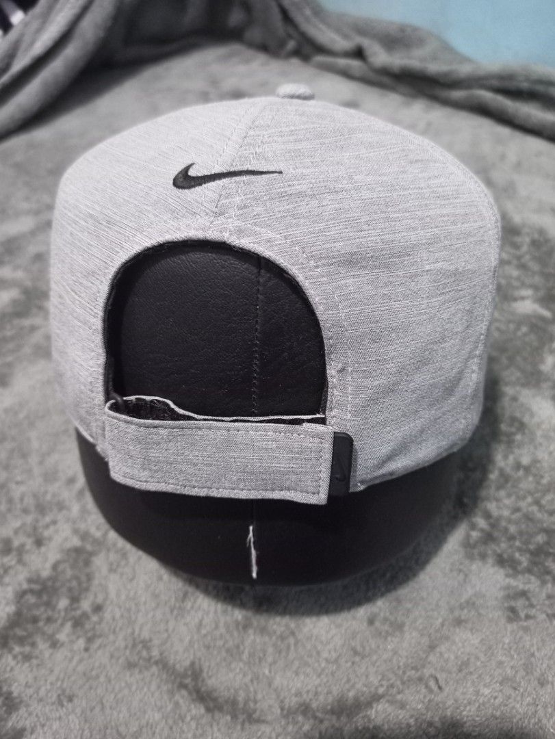 Nike 7 Panel Dri-Fit Gray Athletic Cap with Swoosh Logo (Category: Caps & Hats) located in Manila. Submitted by thecomftrift.co (Listing ID 1466324694, Image 2). Description: Gray Nike cap with a classic black embroidered Swoosh logo on the front and back. Features laser-perforated ventilation holes along the sides for airflow during workouts or runs. Adjustable hook-and-loop strap in the back for a custom fit. Textured heather-style fabric all o