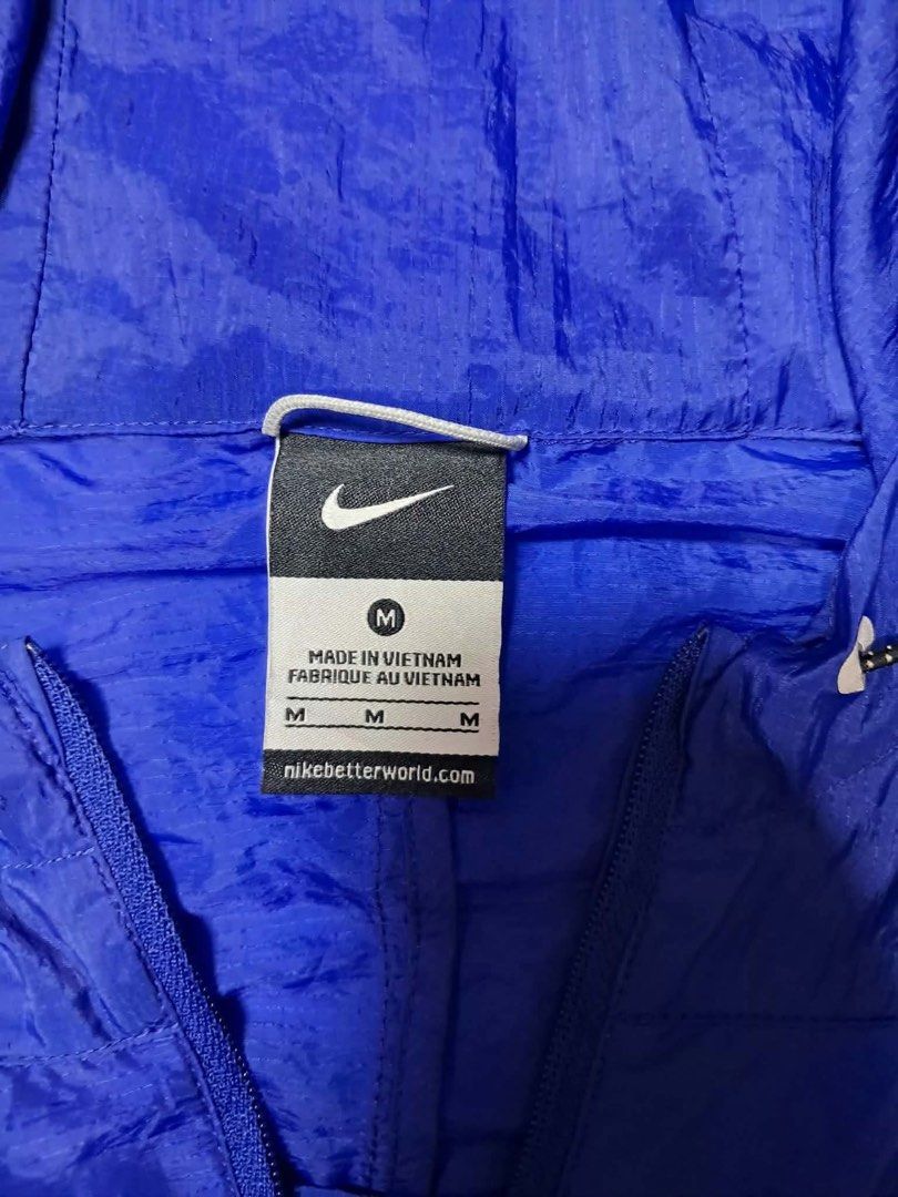 Nike Blue Windbreaker Jacket Medium (Category: Coats, Jackets and Outerwear) located in Baguio. Submitted by padisellsz (Listing ID 1466244637, Image 2). Description: - Brand: Nike - Very good condition - may print transfer sa may shoulder (check pics) - Style: Royal blue windbreaker with hood and quarter zip - Details: Grey stripe accents on shoulders, packs into its own pouch - Material: 100% lightweight nylon (Made in Vietnam) - Size: Medium (