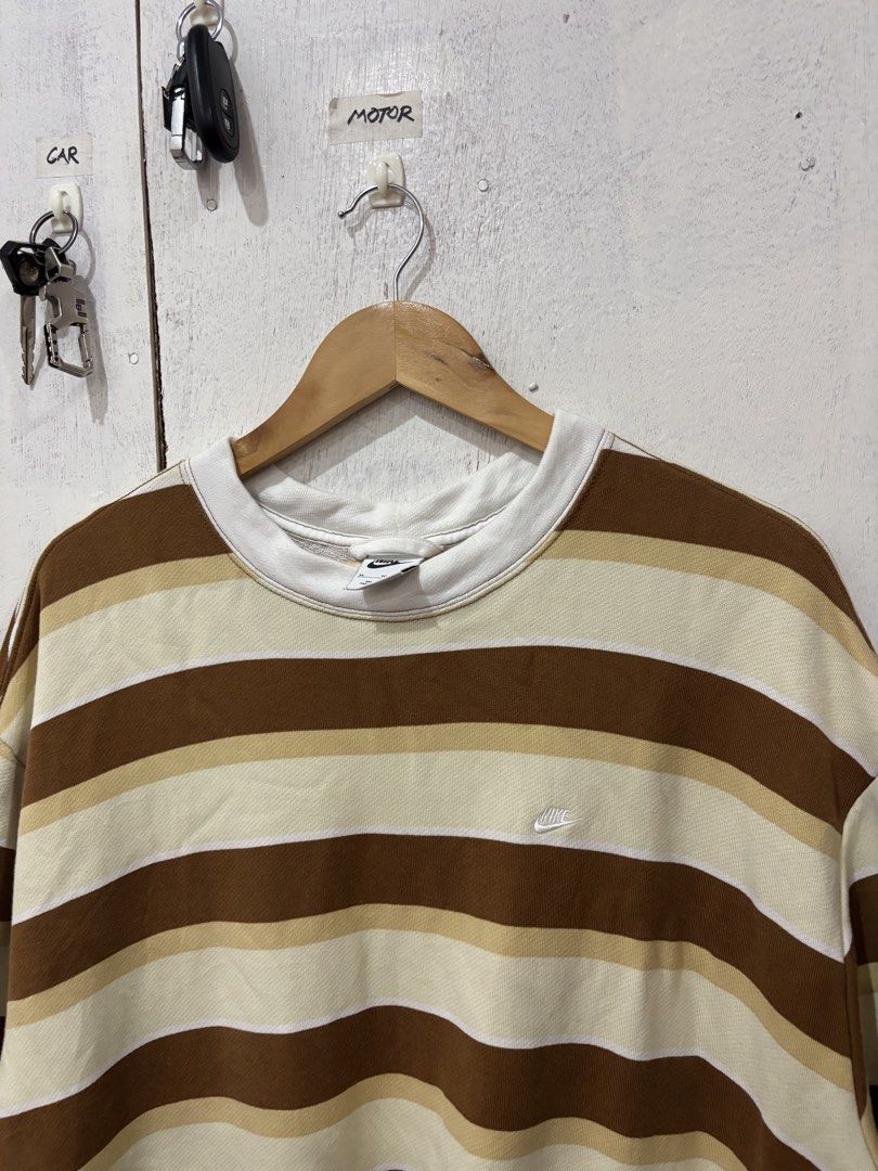 Nike Brown Striped Sweatshirt XL (Category: Coats, Jackets and Outerwear) located in Manila. Submitted by noribrahim.20 (Listing ID 1466272002, Image 2). Description: - Brand: Nike - Style: Striped crewneck sweatshirt (brown, beige, and white) - Size: XL - Details: Small embroidered swoosh on chest, large bold 'nike.' print on the back, comfortable French terry lining - Condition: Good overall with a minor smudged stain on the lower sleeve - Orig