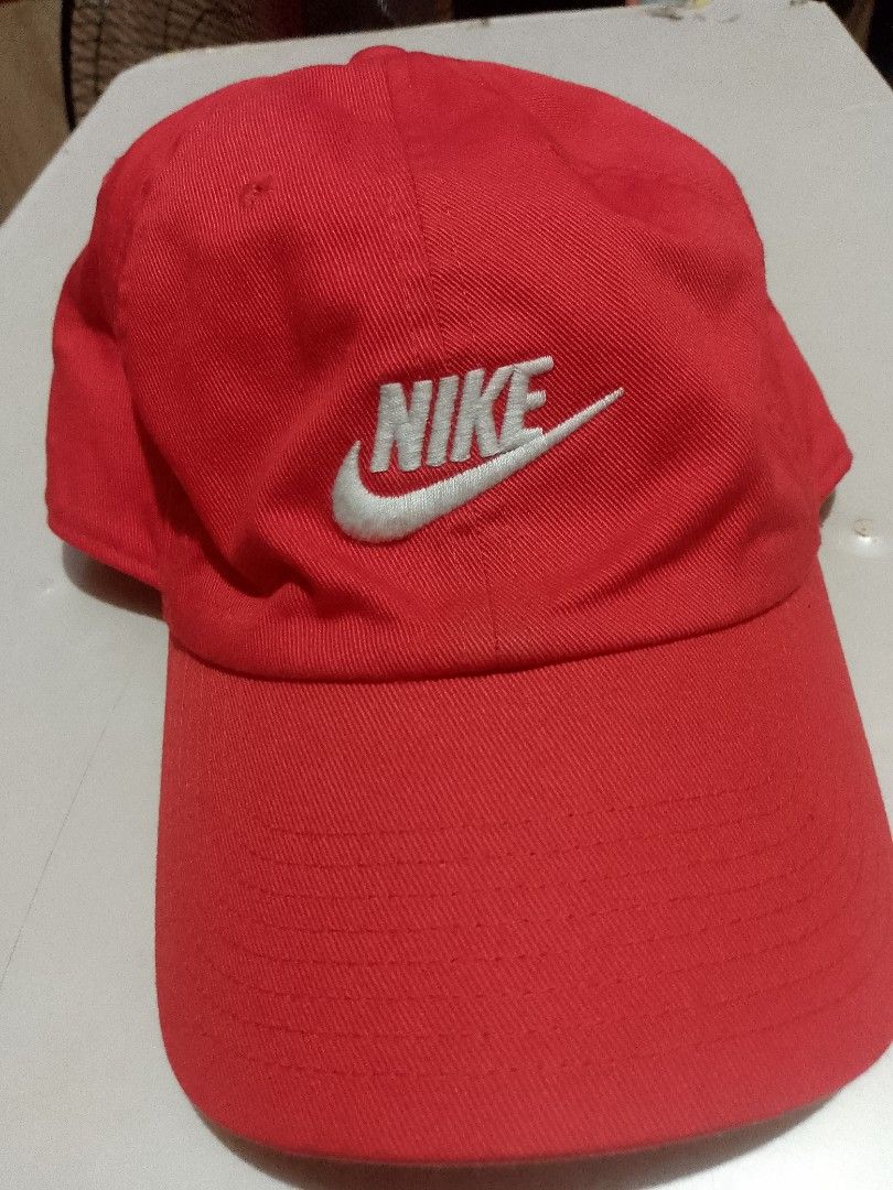 Nike Club Cap Red from US (Category: Caps & Hats) located in Manila. Submitted by martinezvp25582 (Listing ID 1466268519, Image 1). Description: - Brand: Nike - Color: Bright Red - Style: Classic curved brim with white embroidered logo - Material: 100% cotton body and lining - Size: M/L - Closure: Adjustable back strap with metal buckle - Condition: Clean fabric inside and out.