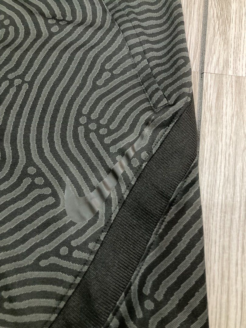 Nike Dri-FIT Patterned Athletic Shorts Size L (Category: Shorts) located in Trece Martires City. Submitted by thriftkoto.91 (Listing ID 1466256361, Image 2). Description: Nike Dri-FIT athletic shorts in black with a wavy fingerprint style graphic pattern throughout. Size large tag inside waistband. Elastic waist design with solid black side panels and reflective Nike swoosh logo near the hem. Made in Cambodia from lightweight moisture-wicking fab