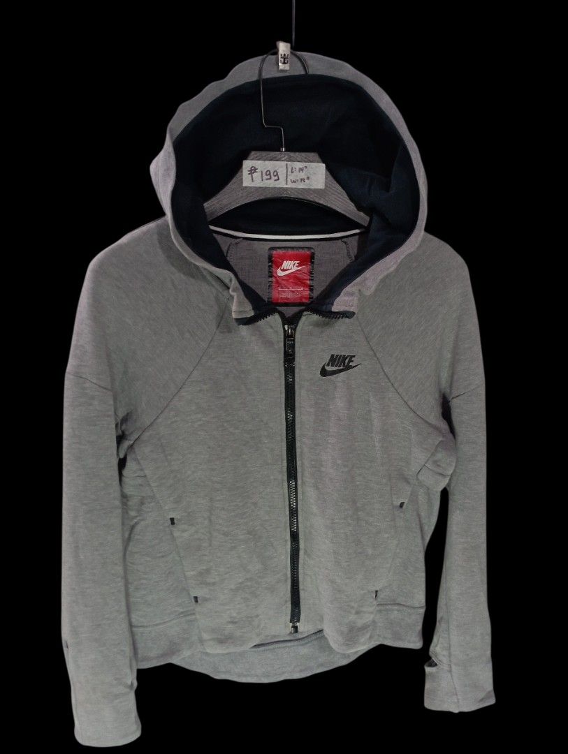 Nike Grey Zip-Up Hoodie Extra Small (Category: Hoodies) located in Rodriguez. Submitted by enzo.tv (Listing ID 1466325964, Image 2). Description: Grey zip-up hoodie from Nike. Black Swoosh logo on the chest. Contrasting dark blue hood lining. Full zipper closure up the front. Tagged extra small size. Measures fourteen inches in length by twelve inches in width..