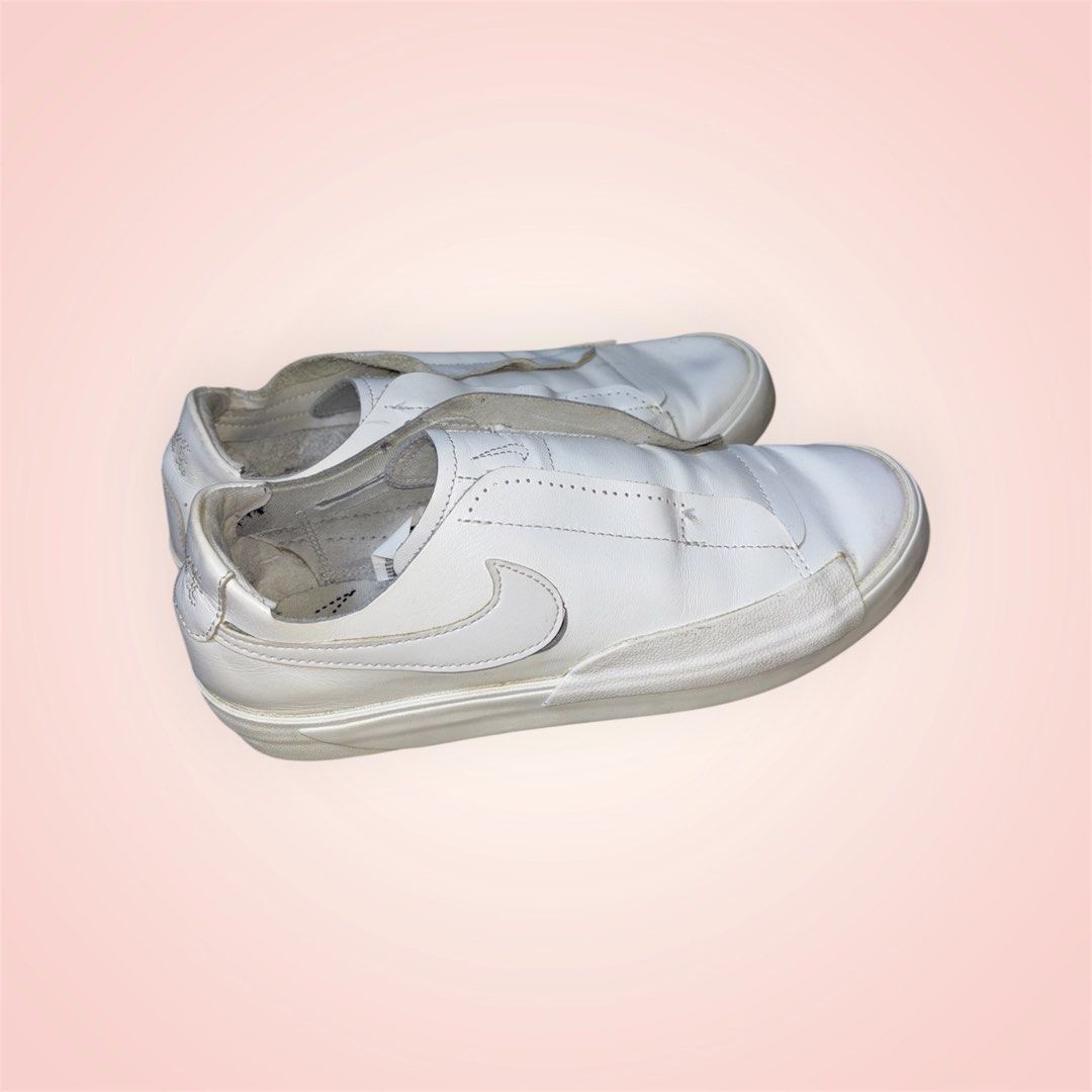 Nike White Leather Slip-On Sneakers (Category: Sneakers) located in Rosario. Submitted by preloveditems2002 (Listing ID 1466241406, Image 2). Description: - Brand/Model: Nike white slip-on sneakers - Material: Premium leather with clean finish - Detail: Embroidered Nike lettering on the back heel - Style: Easy slip-on design for daily errands and casual hangouts - Condition: Minor wear around soles and edges, overall clean and ready to wear - US 