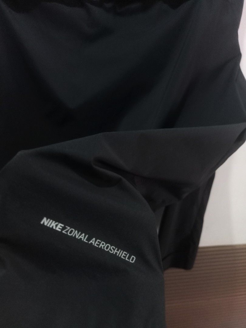 Nike Windbreaker Aeroshiel Jacket Black XL (Category: Coats, Jackets and Outerwear) located in Taguig. Submitted by mvdsh0p2022 (Listing ID 1466279725, Image 3). Description: Nike Zonal Aeroshield jacket in black. Men size XL. Full zip front with attached hood. Reflective swoosh logo on chest and lettering on sleeve. Vented back yoke for breathability. Lightweight weather-resistant fabric. Clean look, ready for outdoor runs or daily wear. N.i.k.e