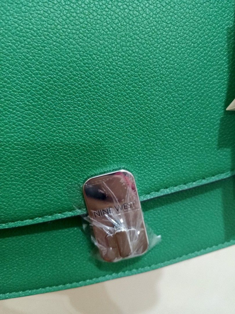 Nine West Green Shoulder Bag (Category: Shoulder Bags) located in Bacoor. Submitted by stardys8888 (Listing ID 1466289204, Image 3). Description: - Brand: Nine West - Color: Bright green - Material: Textured faux leather - Hardware: Silver-tone with protective plastic still attached - Strap: Silver chain shoulder strap - Condition: Brand new with tags, pristine exterior, clean interior - Closure: Structured flap with metal clasp.