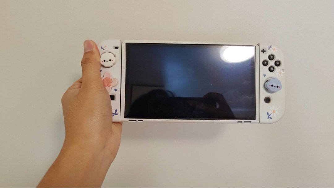 Nintendo Switch OLED Bundle with Games and Case (Category: Nintendo) located in Subic. Submitted by mhntrinidad (Listing ID 1466217449, Image 2). Description: Nintendo Switch OLED console inside a floral protective case. Includes matching thumb grips, 5 game cartridges, carrying case, and Animal Crossing amiibo cards. Everything fits neatly inside the case. Great portable setup ready for gaming right away..