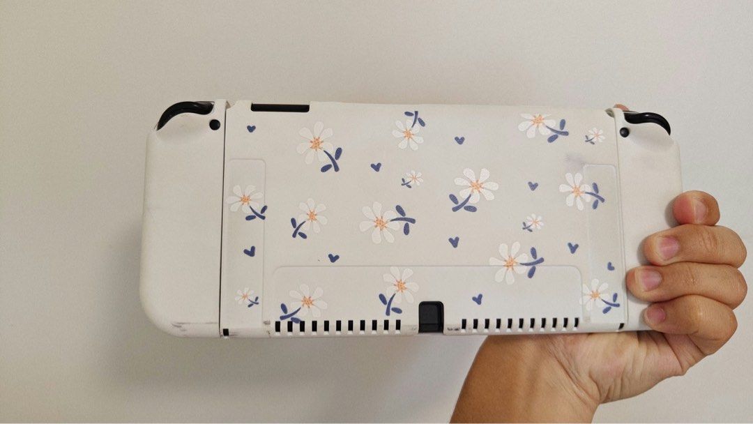 Nintendo Switch OLED Bundle with Games and Case (Category: Nintendo) located in Subic. Submitted by mhntrinidad (Listing ID 1466217449, Image 3). Description: Nintendo Switch OLED console inside a floral protective case. Includes matching thumb grips, 5 game cartridges, carrying case, and Animal Crossing amiibo cards. Everything fits neatly inside the case. Great portable setup ready for gaming right away..