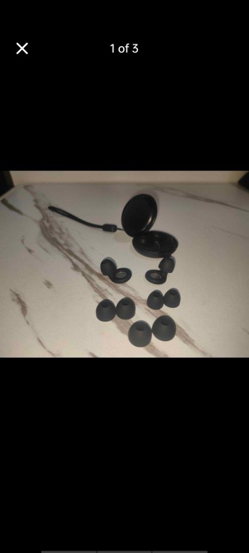 Noise cancelling earplugs (Category: Earphones) located in Manila. Submitted by billythekid05 (Listing ID 1466277304, Image 1). Description: - Sleek black wireless earplugs with a compact round charging case - Includes a convenient wrist strap for easy carrying - Comes with multiple extra silicone ear tips for a custom, comfortable fit - Stylish marble-patterned backdrop (item only, background not included) - Perfect for sleeping .