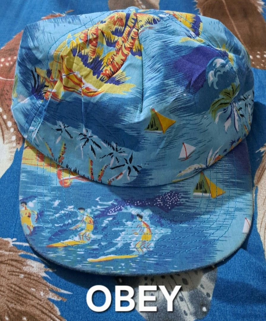 Obey Tropical Surfer Print 5-Panel Cap Blue (Category: Caps & Hats) located in San Fernando, Camarines Sur. Submitted by ladderaya (Listing ID 1466230803, Image 1). Description: - Brand: Obey - Design: All-over tropical surf print with palm trees and wave graphics - Color: Blue colorway - Material: 100% Cotton - Closure: Adjustable strapback with a sleek leather-like strap - Origin: Made in China - Condition: Clean streetwear piece, ready to wear