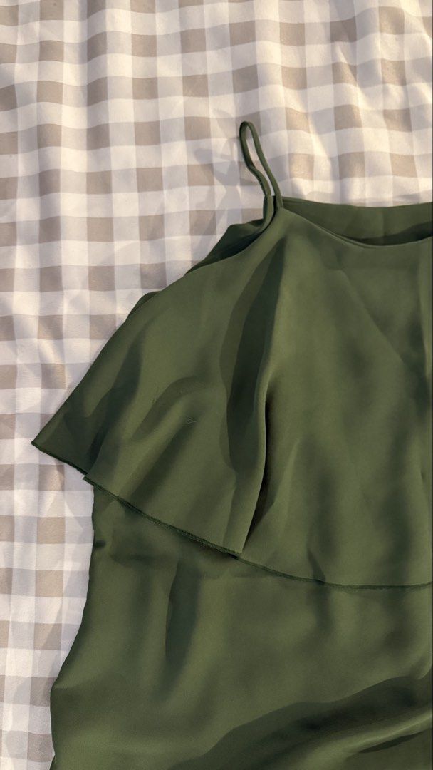 Olive green spaghetti strap ruffle overlay camisole top (Category: Sleeveless) located in Muntinlupa City. Submitted by addielejano (Listing ID 1466267084, Image 2). Description: - Color: Dark olive green - Style: Camisole with thin spaghetti straps - Design: Layered ruffle overlay draping over the shoulders - Fabric: Lightweight and breathable - Condition: Clean, excellent, ready to wear Fits S-M.