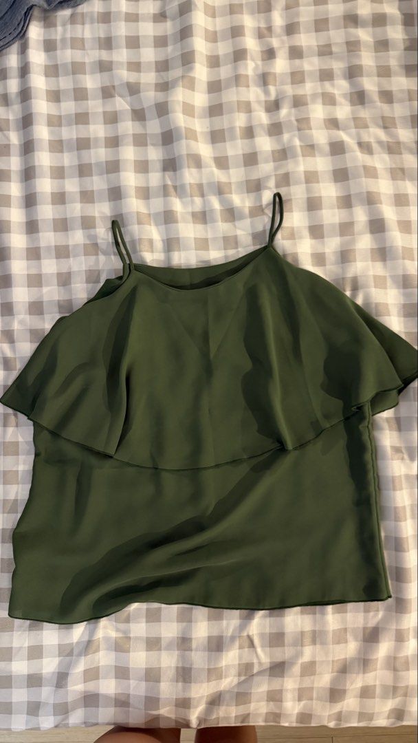 Olive green spaghetti strap ruffle overlay camisole top (Category: Sleeveless) located in Muntinlupa City. Submitted by addielejano (Listing ID 1466267084, Image 1). Description: - Color: Dark olive green - Style: Camisole with thin spaghetti straps - Design: Layered ruffle overlay draping over the shoulders - Fabric: Lightweight and breathable - Condition: Clean, excellent, ready to wear Fits S-M.