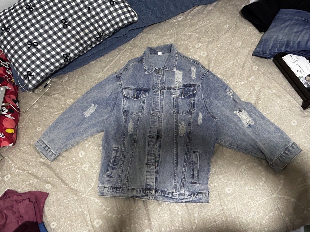 Oversized Distressed Blue Denim Jacket with Rips (Category: Coats, Jackets and Outerwear) located in Caloocan City. Submitted by hansev (Listing ID 1466289180, Image 2). Description: - Style: Oversized fit denim jacket - Color: Light wash blue - Design: Button-up front, classic collar, and button cuffs - Pockets: Functional chest and lower side pockets - Details: Trendy distressed rips on the chest, sleeves, and lower back - Versatility: Easy to 