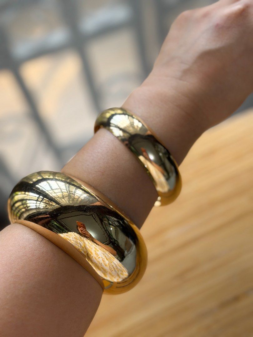 Oversized Gold Bangles (Set of 2) (Category: Accessory Holder, Box & Organizers) located in Pasig City. Submitted by paolasoriano_wind (Listing ID 1466214526, Image 2). Description: Lightly used. Condition: 9/10 (with minimal signs of use) NOT real gold! Fancy jewelry only. Don’t be picky (this is preloved and cheap). Fits small to medium wrist size. Chic and stylish. Wear with oversized tops and polos. See ways to style on last pic. .