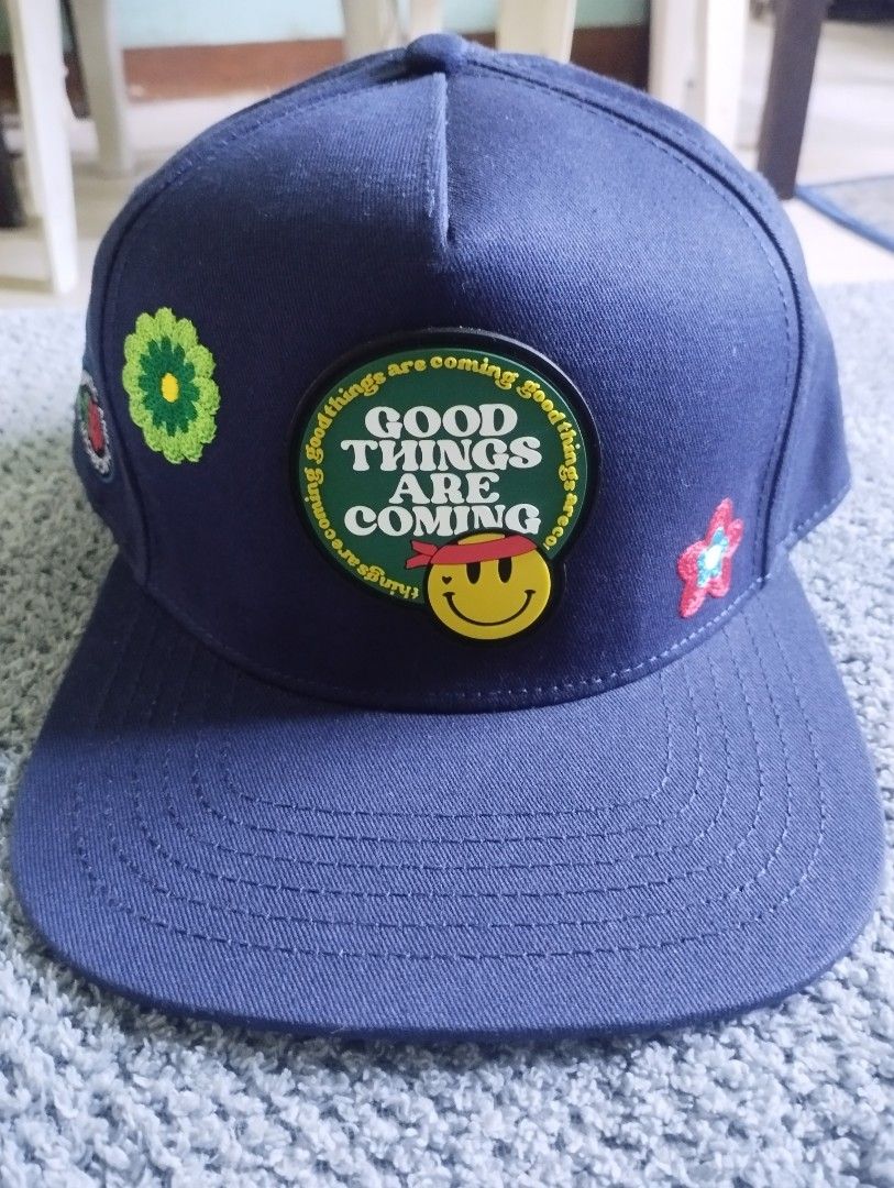 PD Club Good Things Are Coming Snapback Hat (Category: Caps & Hats) located in Manila. Submitted by happycaps (Listing ID 1466173638, Image 1). Description: - Brand: Problematic and Dangerous Club - Color: Navy blue - Design: Large rubberized 'Good Things Are Coming' smiley patch on the front - Details: Embroidered flowers on the sides and a rose graphic on the lower side panel - Fit: Adjustable snapback closure with PD Club tag - Interior: Brand