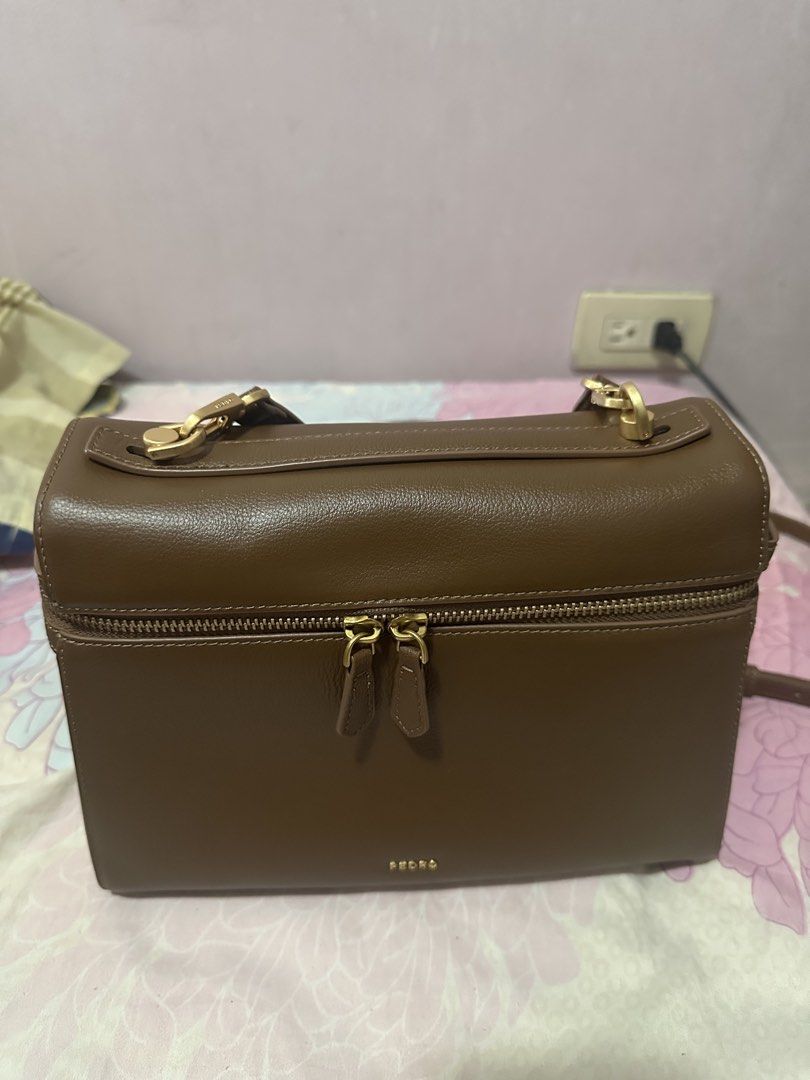 Pedro Genuine Leather Backpack (Category: Shoulder Bags) located in Mandaluyong City. Submitted by jeninaheart (Listing ID 1466159662, Image 1). Description: - Brand: Pedro - Material: Brown leather with clean stitching - Hardware: Gold-tone - Closure: Zipper across the front flap - Strap: Adjustable and detachable via lobster clasps - Interior: Beige lining with an inner zipper pocket and brand tag.