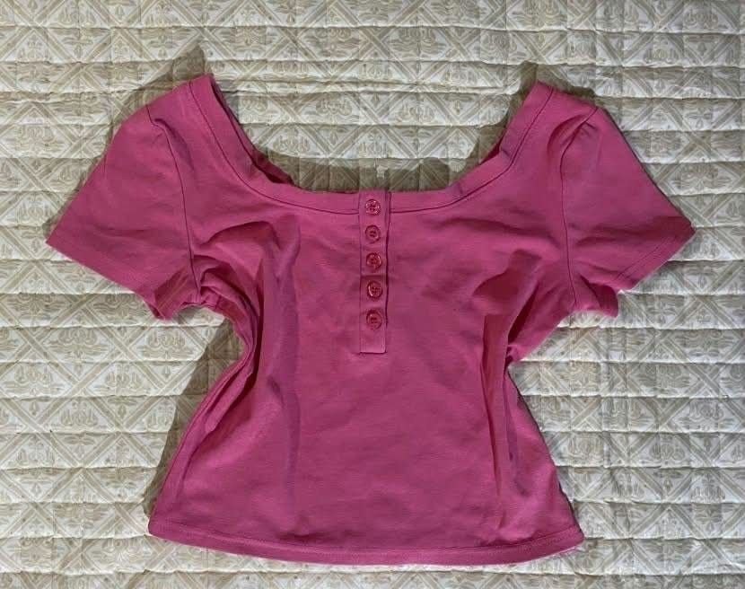 Pink Crop Top with Button Details (Category: Others Tops) located in Pagadian. Submitted by kahtlopez47867 (Listing ID 1466318329, Image 1). Description: - Color: Bright pink - Style: Short sleeve crop top with scoop neckline - Details: 5 matching front buttons - Material: Stretchy ribbed cotton - Pairing: Perfect with high-waisted jeans or skirts.