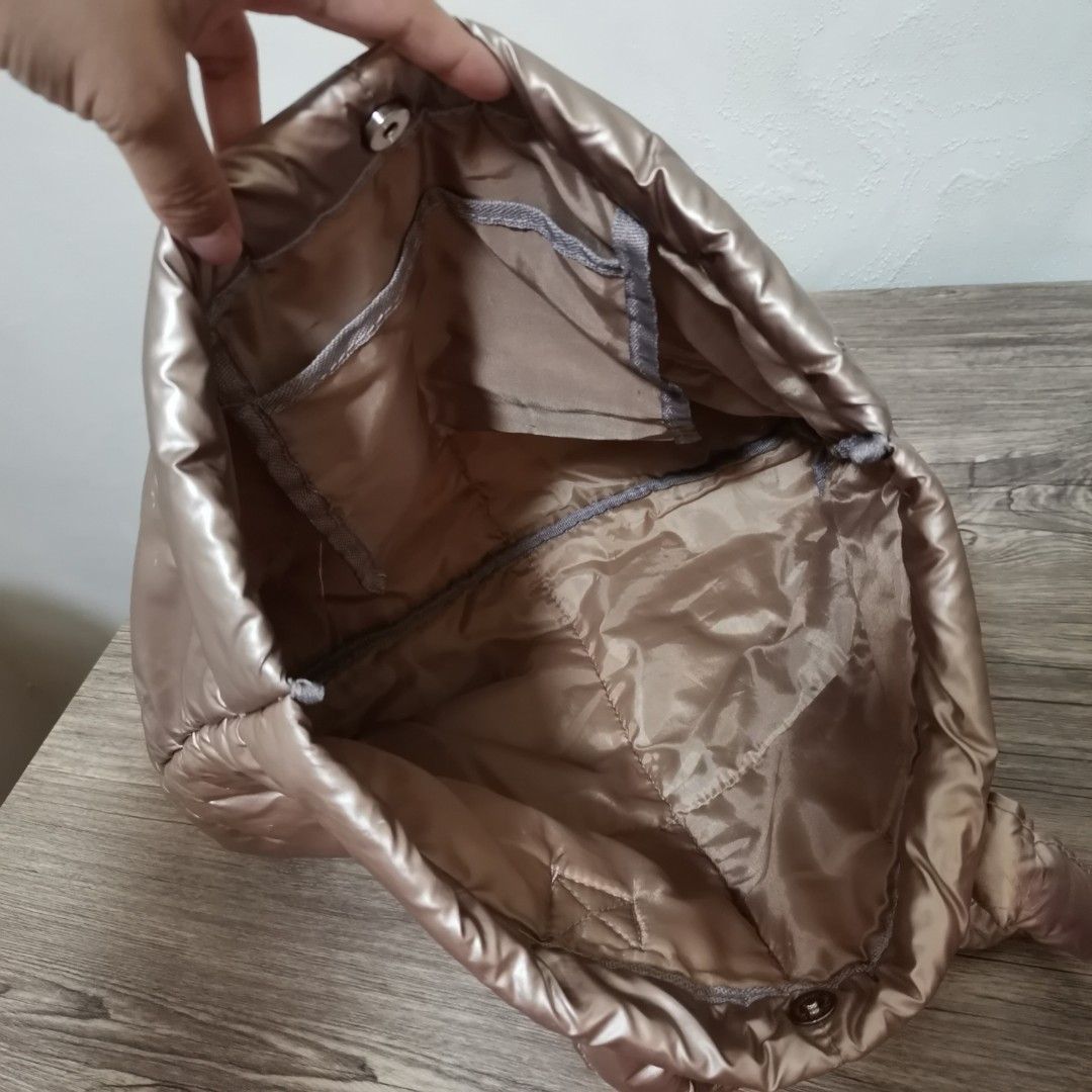 Puffer Tote Bag (Category: Tote Bags) located in Bacoor. Submitted by bloomingpetals (Listing ID 1466200734, Image 3). Description: Surplus Puffer Tote Bag ₱150 FIXED PRICE • Beige/taupe color • Size: 33 × 25 × 15 cm • Material: Nylon Metallic • Puffer/padded design • Magnetic closure • With 1 inner pocket • Lightweight and spacious • Can be carried by hand or on the shoulder • Suitable for everyday/casual use Condition: Well-used preloved ⚠️ Ple