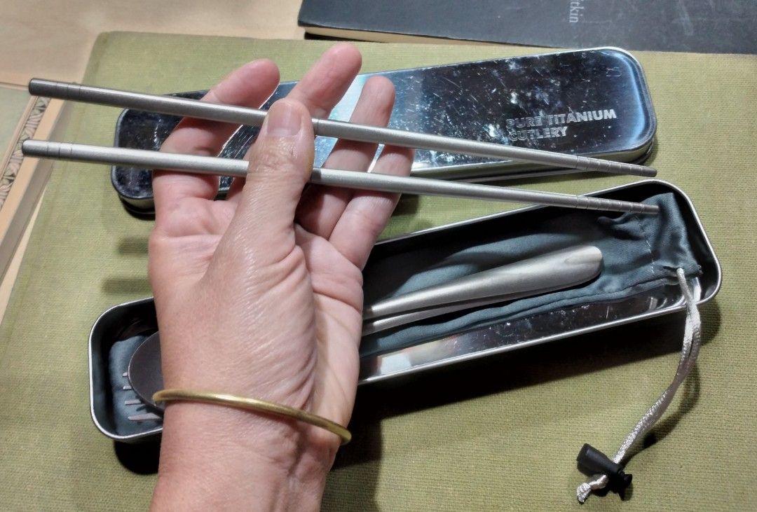 Pure Titanium Cutlery Set Spoon Fork Chopsticks with Case (Category: Dinnerware & Cutlery) located in Baguio. Submitted by tipiditis (Listing ID 1466249079, Image 2). Description: - Material: 100% Pure Titanium (Super lightweight and durable) - Set includes: Chopsticks, fork, and spoon - Inclusions: Metallic storage case and grey pouch - Best for: Camping, traveling, office, and school lunches - Condition: Brand new utensils, minor scratches on t