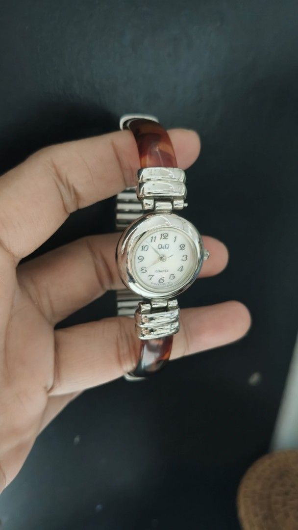 Q&Q Quartz Watch Tortoise Shell and Silver Bracelet (Category: Women's Watches) located in Taguig. Submitted by mercyeugen28914 (Listing ID 1466291692, Image 1). Description: - Brand: Q&Q - Movement: Battery-operated quartz - Dial: Round white face with easy-to-read black numeric markers - Strap: Chic combination of silver-tone metal and tortoise shell resin links - Fit: Comfortable on the wrist - Condition: Minor surface scratches from regular w