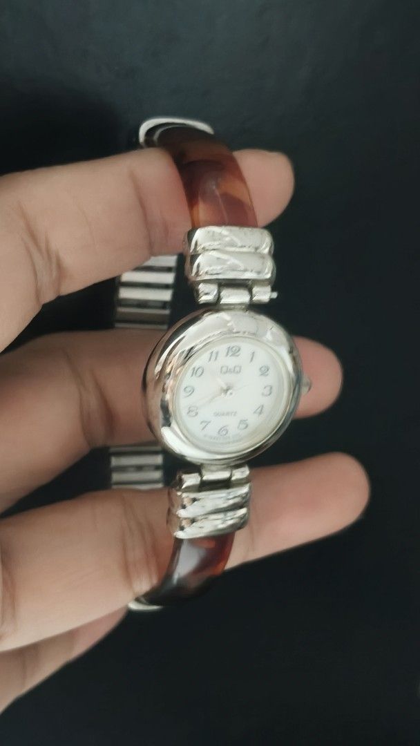 Q&Q Quartz Watch Tortoise Shell and Silver Bracelet (Category: Women's Watches) located in Taguig. Submitted by mercyeugen28914 (Listing ID 1466291692, Image 2). Description: - Brand: Q&Q - Movement: Battery-operated quartz - Dial: Round white face with easy-to-read black numeric markers - Strap: Chic combination of silver-tone metal and tortoise shell resin links - Fit: Comfortable on the wrist - Condition: Minor surface scratches from regular w