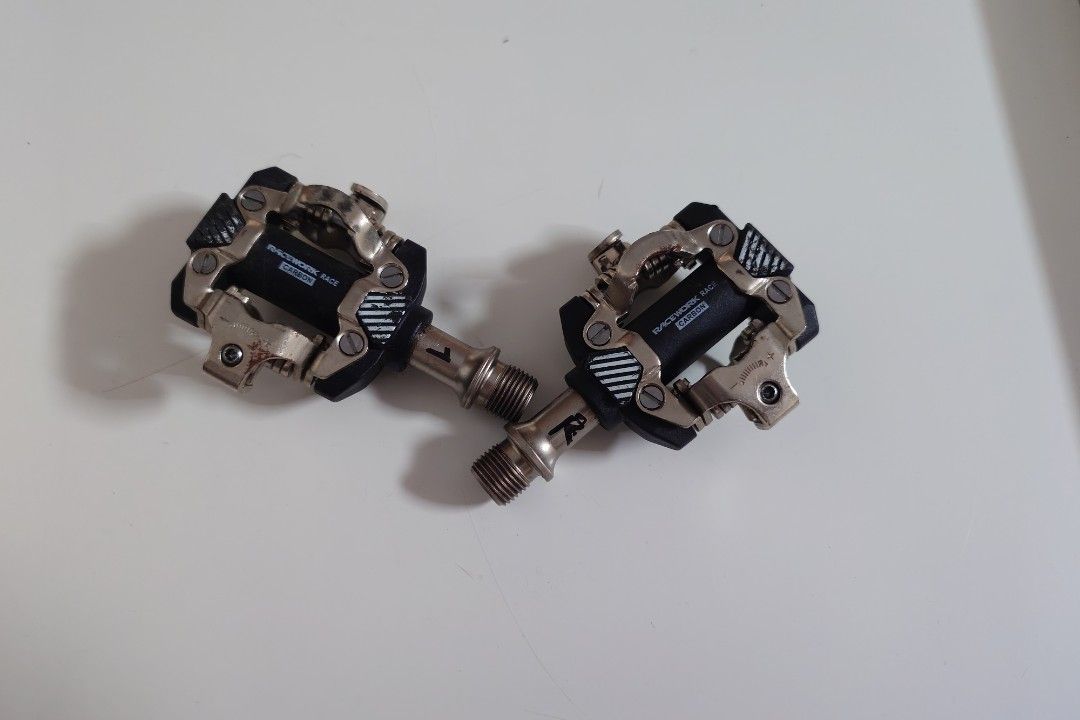 RaceWork Clipless Pedals (Category: Parts & Accessories) located in Singapore. Submitted by stickybean (Listing ID 1466216043, Image 1). Description: Pair of RaceWork Race Carbon clipless pedals for mountain bikes. Left and right pedals included with standard threaded spindles. metal retention mechanisms and adjustable tension settings. Signs of previous use visible with minor scuffs and surface wear on the metal parts..