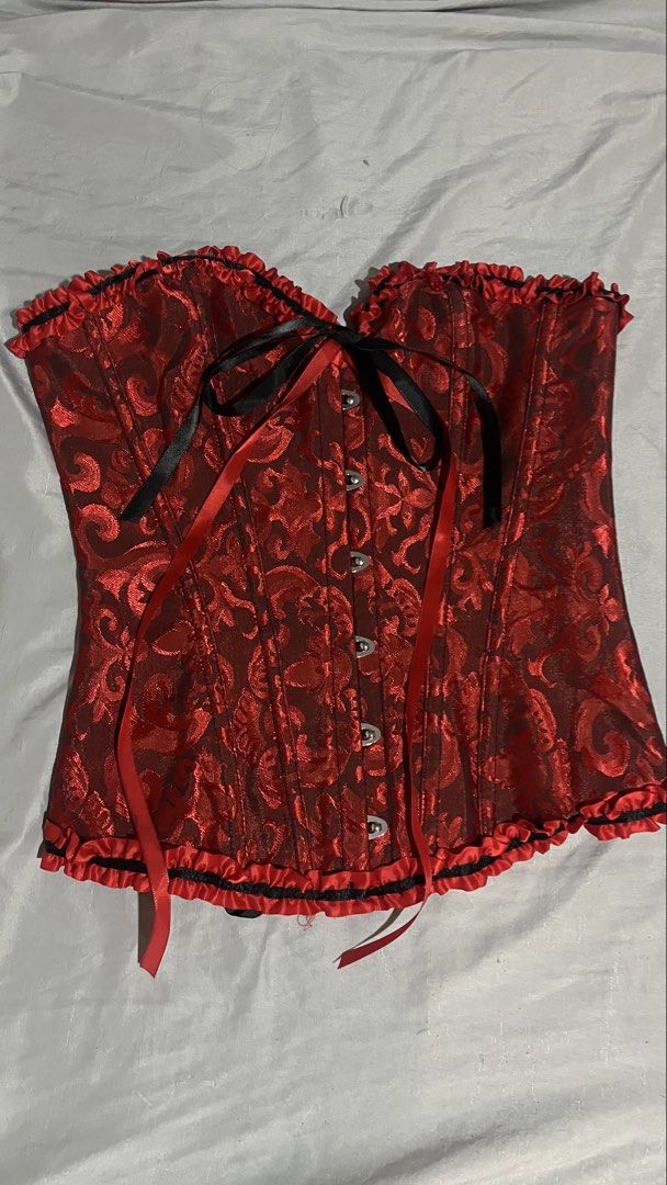 Red Corset With Black Ruffles Size S (Category: Sleeveless) located in Manila. Submitted by natalierenee.baltazar-38452 (Listing ID 1466190578, Image 1). Description: - Size: Small - Color/Pattern: Red and black with detailed damask design - Material: 90% polyester, 10% spandex (hand wash only) - Closure: Front metal busk with secure clasps - Fit: Traditional black ribbon lace-up back for custom adjustment - Style Details: Ruffled trim along top 